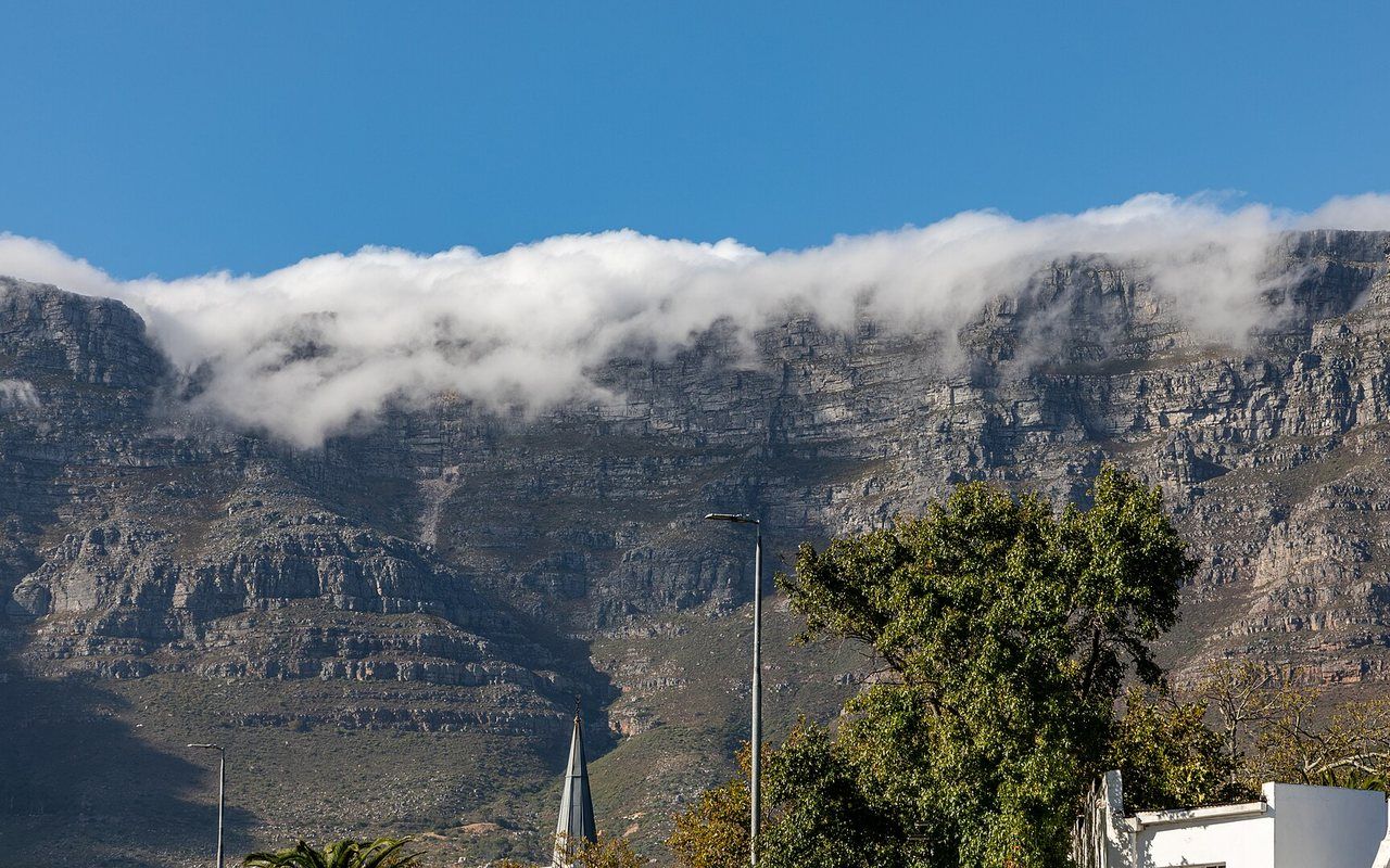 A flat-topped mountain above a dense coastal city and curving bay